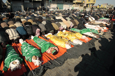 Mourners pray beside bodies of Palestinians in Gaza